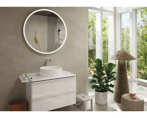 Helles Badezimmer mit rundem Spiegel, Waschbecken und Unterschrank