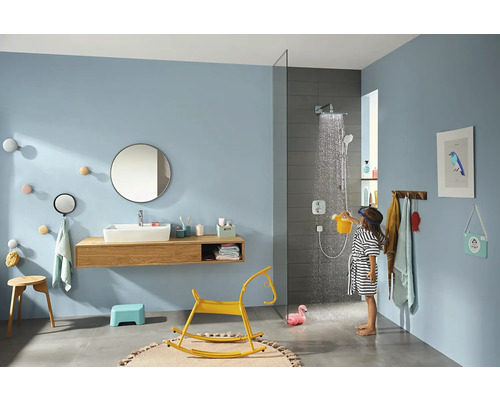 Helles Badezimmer mit Dusche, Waschbecken, Spiegel und spielendem Kind