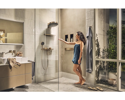 Helles Badezimmer mit Dusche, Waschtisch und Handtüchern für ein entspannendes Ambiente
