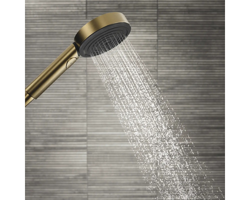 Handbrause mit Wasserstrahl vor Wandfliesen