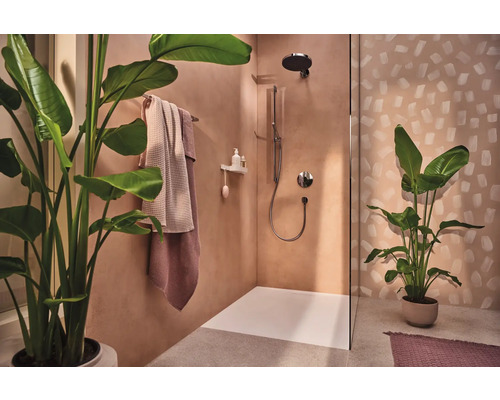 Badezimmer mit Dusche, Handtüchern und Topfpflanzen für eine natürliche Atmosphäre