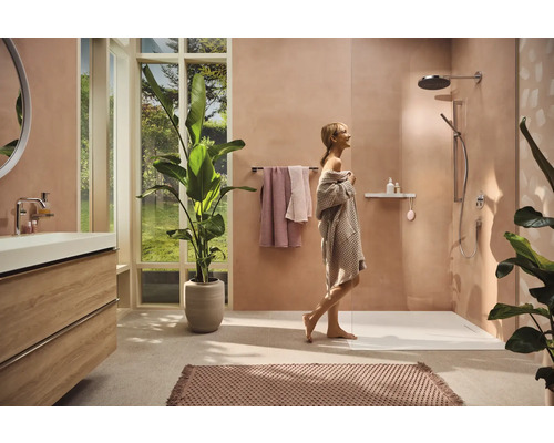 Helles Badezimmer mit Dusche, Waschbeckenunterschrank, Handtüchern und Zimmerpflanzen für eine freundliche Atmosphäre