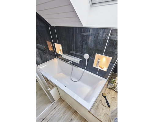 Badezimmer mit Badewanne, Duschkopf und eingelassenen Regalen