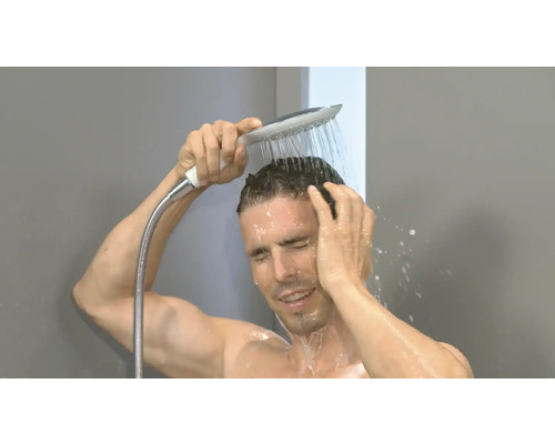 Mann duscht mit Duschkopf