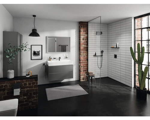 Helles Badezimmer mit Waschtisch, Spiegel, Dusche und Ziegelwand