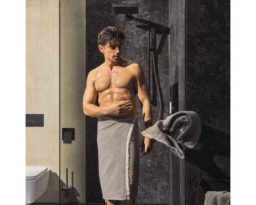 Badezimmer Szene mit Dusche und einer Person mit Handtuch