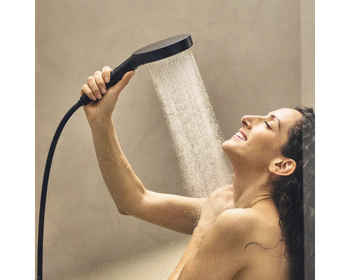 Frau unter Dusche mit Handbrause und Wasserdurchfluss