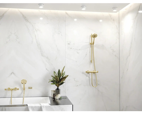 Modernes Badezimmer mit Marmorwänden und goldenen Armaturen.