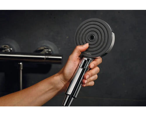 Eine Hand hält eine Handbrause der Marke Hansgrohe.