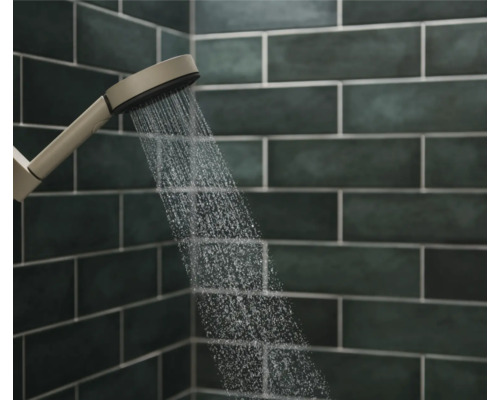 Handbrause mit Wasserstrahl vor dunklem Fliesenhintergrund