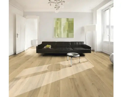 Wohnzimmer mit Holzboden, Sofa und Kunstwerk