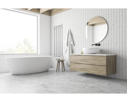 Helles Badezimmer mit freistehender Badewanne, Waschtisch mit rundem Spiegel und Handtuchwärmer