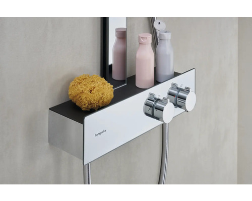 Hansgrohe Logo. Duscharmatur mit Ablagefläche, Waschlotion und Badeschwamm.