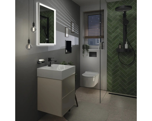 Modernes Badezimmer mit Waschtisch, beleuchtetem Spiegel und Dusche mit grünen Fliesen