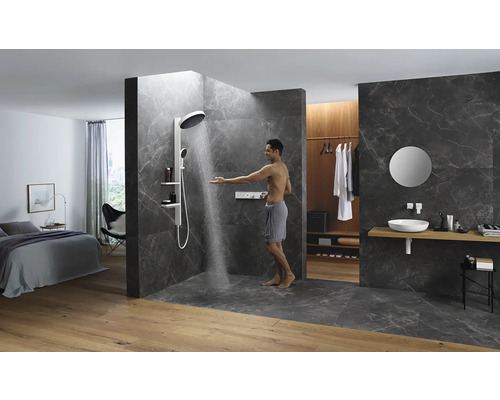 Helles Badezimmer mit Dusche, Waschbecken und Schlafbereich in offenem Design.