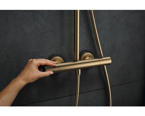 Eine Hand bedient einen Duschthermostat zur Temperaturregelung.