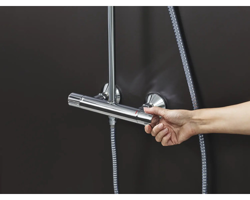 Hand bedient eine Duscharmatur mit Thermostat.