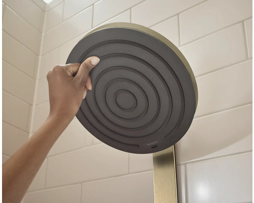 Brausekopf mit konzentrischem Design und Armatur wird von einer Hand gehalten