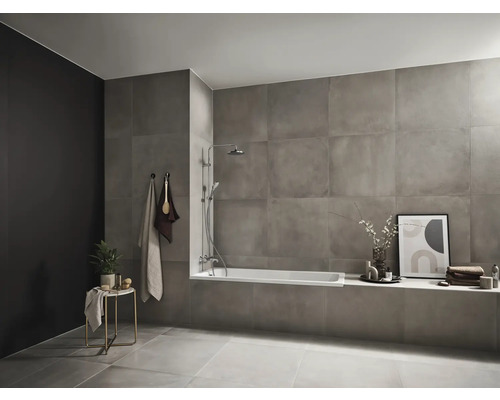 Modernes Badezimmer mit grauen Fliesen, Badewanne und Handtüchern