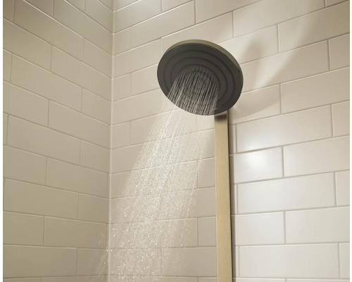 Regendusche mit Wasserstrahl im Badezimmer mit weißen Fliesen