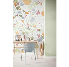 Helles Arbeitszimmer mit Schreibtisch, Stuhl und Wandtapete mit abstraktem Design