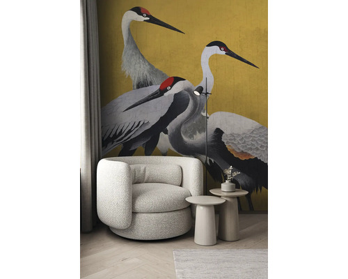 Wohnzimmer-Szene mit Sessel, Beistelltischen, Stehlampe und Tapete mit Kranichmotiv