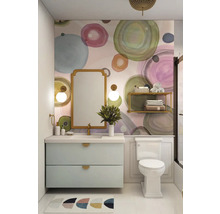 Helles Badezimmer mit Waschbeckenunterschrank, Spiegel und Toilette vor einer Wand mit Kreismuster