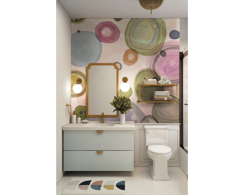 Helles Badezimmer mit Waschbeckenunterschrank, Spiegel und Toilette vor einer Wand mit Kreismuster