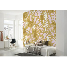 Schlafzimmer mit gemusterter Tapete, Bett, Schreibtisch und Stuhl.