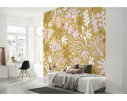 Schlafzimmer mit gemusterter Tapete, Bett, Schreibtisch und Stuhl.