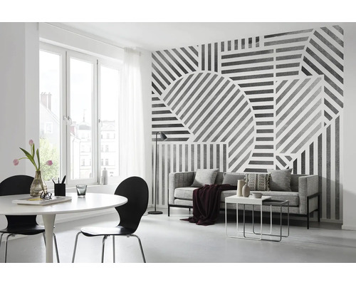 Wohnzimmer mit grafischer Tapete, Sofa, Tisch und Stühlen