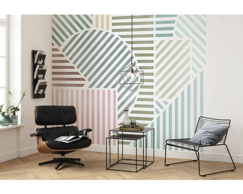 Wohnzimmer mit grafischer Tapete, Sessel und Beistelltischen