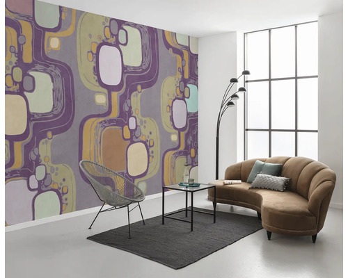 Wohnzimmer mit gemusterter Tapete, Sofa, Sessel und Teppich