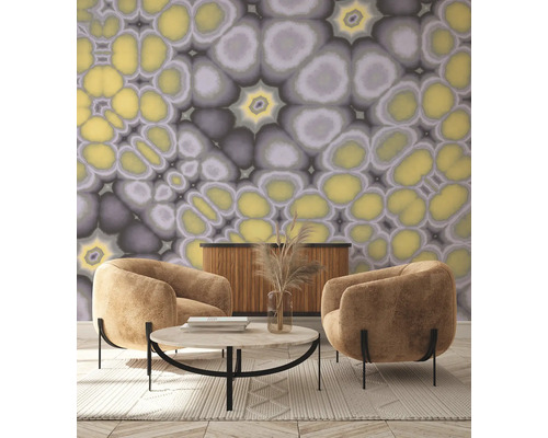 Wohnzimmer mit zwei Sesseln, Couchtisch, Sideboard und Tapete mit abstraktem Muster