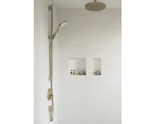 Duscharmatur mit Handbrause und Kopfbrause an einer gefliesten Wand mit eingebauten Regalen.