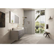 Helles Badezimmer mit Waschtisch, Spiegel, Dusche und Fenster mit Blick in die Natur