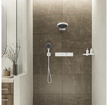 Duschbereich mit Kopfbrause, Handbrause und Armatur vor gefliester Wand