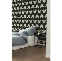 Schlafzimmer mit Bett, Nachttisch und Wandtapete mit Mickey Maus Motiv