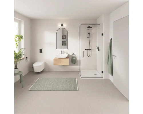 Badezimmer mit Dusche, Waschbecken, Spiegel und Toilette in hellem Design