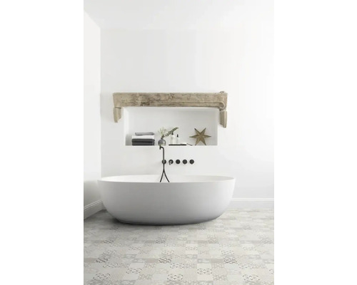 Badezimmer mit freistehender Badewanne, gefliester Boden und Ablagefläche in der Wand