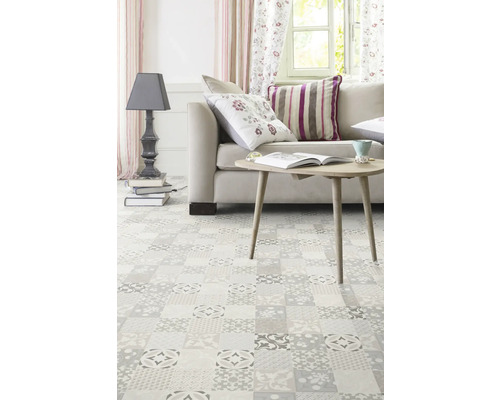 Wohnzimmer mit Couch, Tisch, Stehlampe und Bodenfliesen im Patchwork-Stil