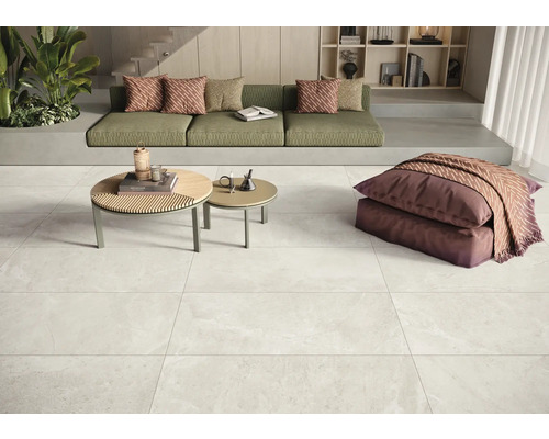 Heller Wohnraum mit Sofa, Couchtischen und Bodenfliesen