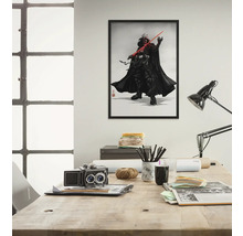 Gerahmtes Poster von Darth Vader mit Lichtschwert an der Wand über einem Schreibtisch