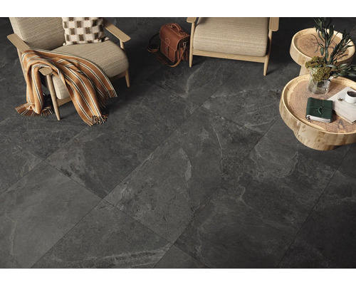 Innenraum mit dunklen Bodenfliesen, zwei Sesseln und Beistelltischen