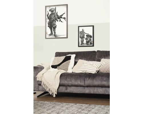 Dekoratives Wohnzimmer mit Sofa, Kissen und gerahmten Illustrationen an der Wand
