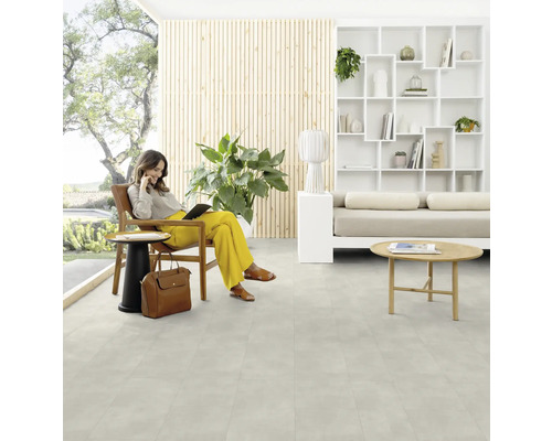 Eine Frau sitzt mit einem Tablet in einem hellen Raum mit Designboden