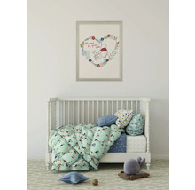 Kinderzimmer mit Gitterbett, Decken und Kissen sowie einem Winnie Puh Bild an der Wand