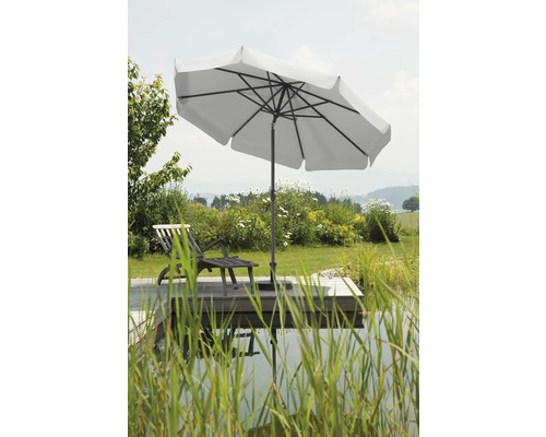 Gartenszene mit Sonnenschirm, Liegestuhl und Teich auf einer Holzterrasse