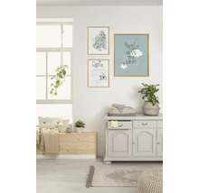 Wohnraum mit drei gerahmten Bildern an der Wand, einer Kommode und einem Fensterbereich mit Sitzgelegenheit