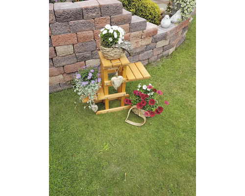 Dekorative Holzleiter mit Blumenarrangements im Garten